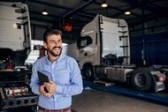 Man standing in front of lorries in a garage