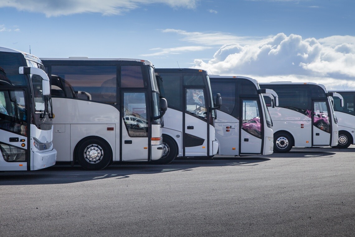 Row of white motor coach buses facing right