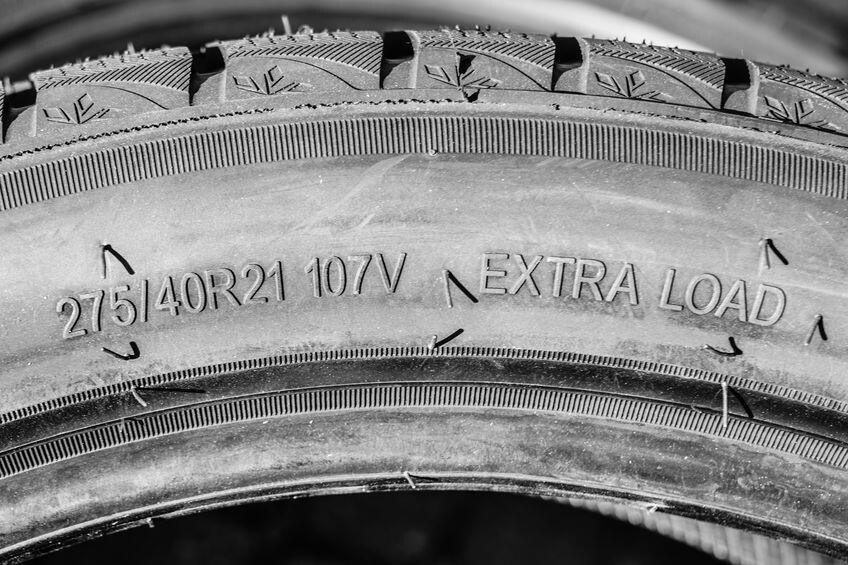 Side view of new tire with tire width, height and wheel diameter designations and speed and load indices