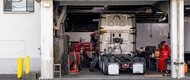 Commercial truck undergoing maintenance in a fleet service shop with truck tires prepared for inspection and potential retreading to extend tire life and reduce operating costs.