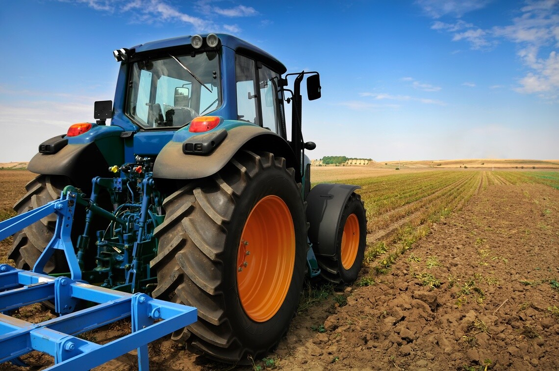 Agricultural tractor with large tires working in a field