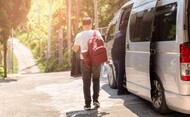 Traveler boarding a passenger van with luggage