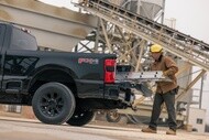 Worker loading a ladder into a commercial pickup truck equipped with Michelin Agilis tires