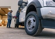 Worker beside a light-duty commercial work truck equipped with Michelin Agilis tires