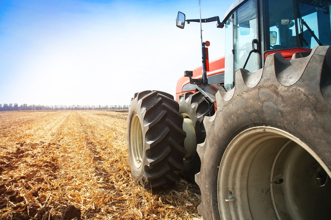 Agricultural tractor tires driving through crop stubble in a harvested field