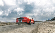 Ford Mustang kicking up dirt as it accelerates quickly