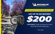 Michelin Pilot Sport 4S on a road with purple trees on the left hand side Michelin offer from 1st september until end of november $200 cashback on select Michelin tyres