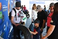 展示されたMotoEタイヤを見る人々