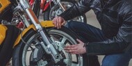 オートバイのタイヤを点検する男性
