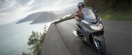 バイクで海岸沿いの道路を走行するライダー