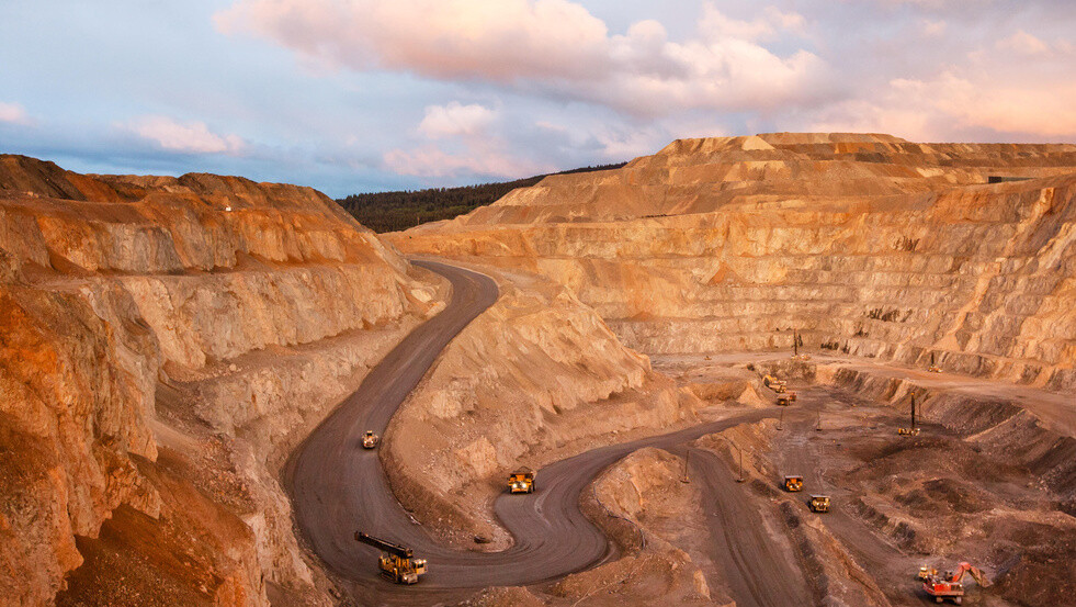 A top view of a mining quarry with multiple mining vehicles at work.
