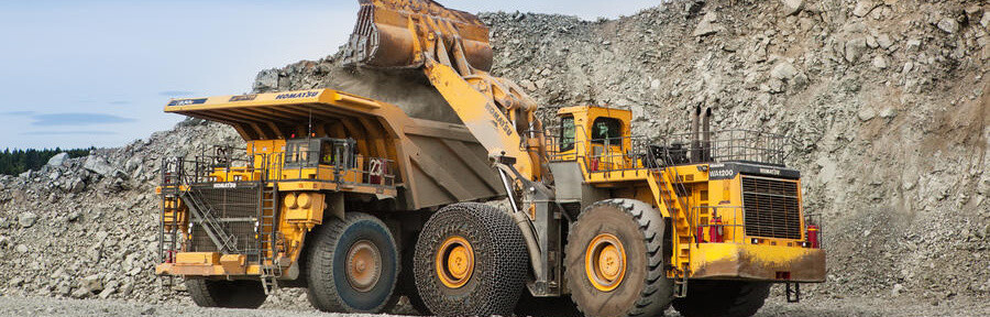 Two large mining vehicles at work in a quarry.
