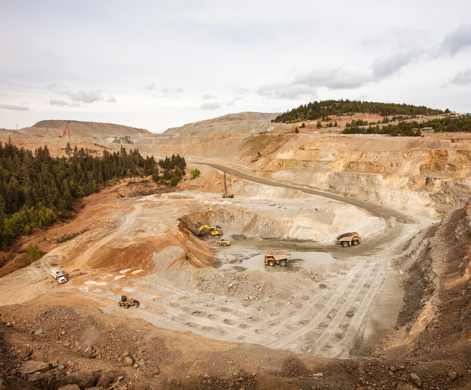 A mining quarry with a few trucks actively working.